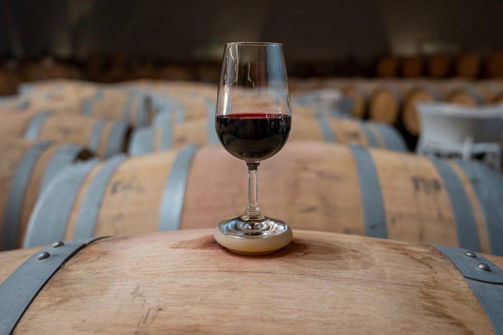 Copa de vino Rioja sobre barriles